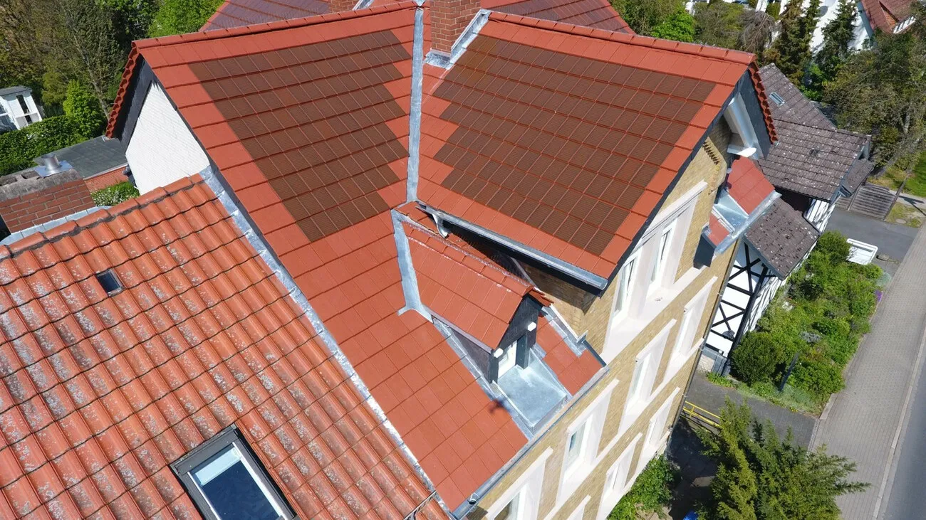 Ton in Ton: Dach und Solarziegel sind beide rot, dass die Photovoltaikanlage auf dem Dach kaum auffällt.